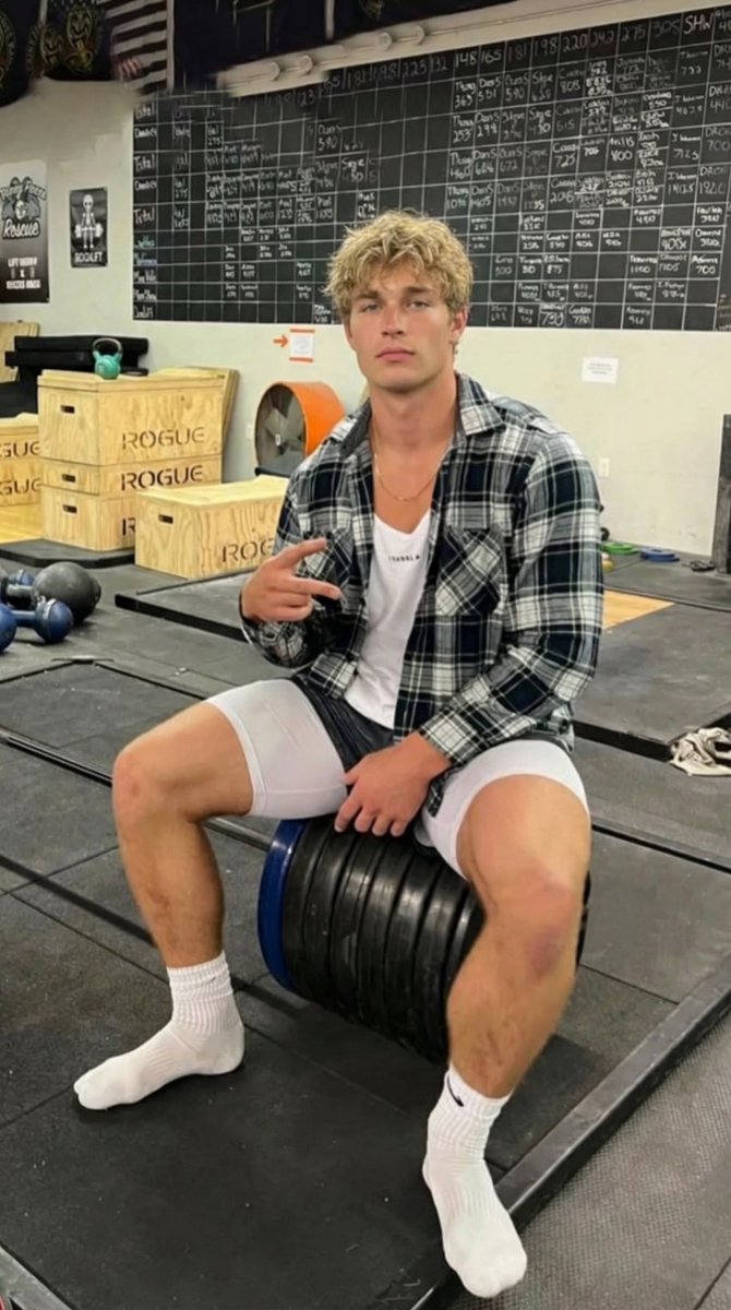 坐杠铃片上的金发运动帅哥